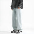 Men's light blue washed cotton straight leg jeans with button waist, laid flat.