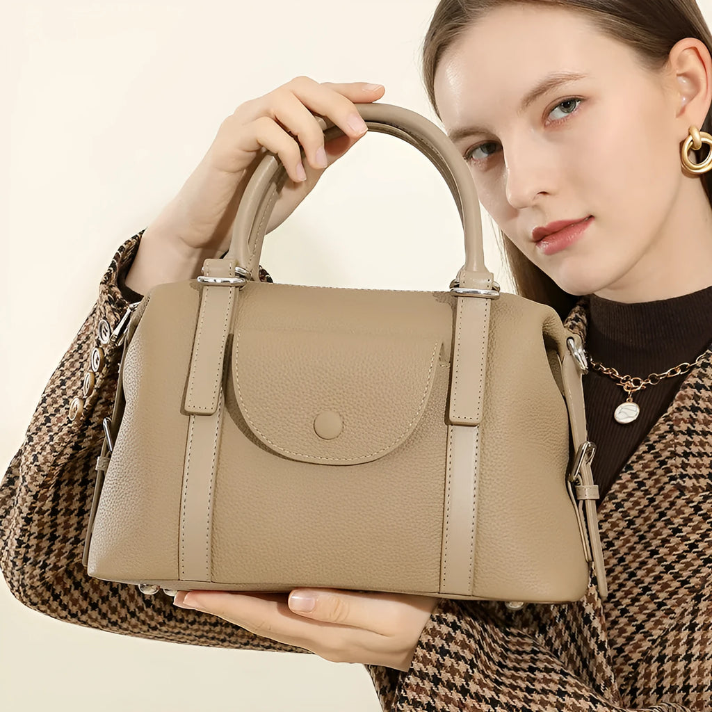 Genuine leather ladies handbag in black, brown, or elephant grey with contrast stitching and a lock.