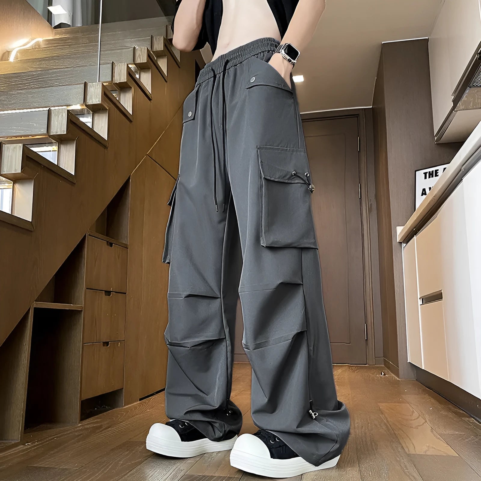 A woman wearing thin, loose, straight-leg waterproof trousers in a solid colour with an elastic drawstring waist.