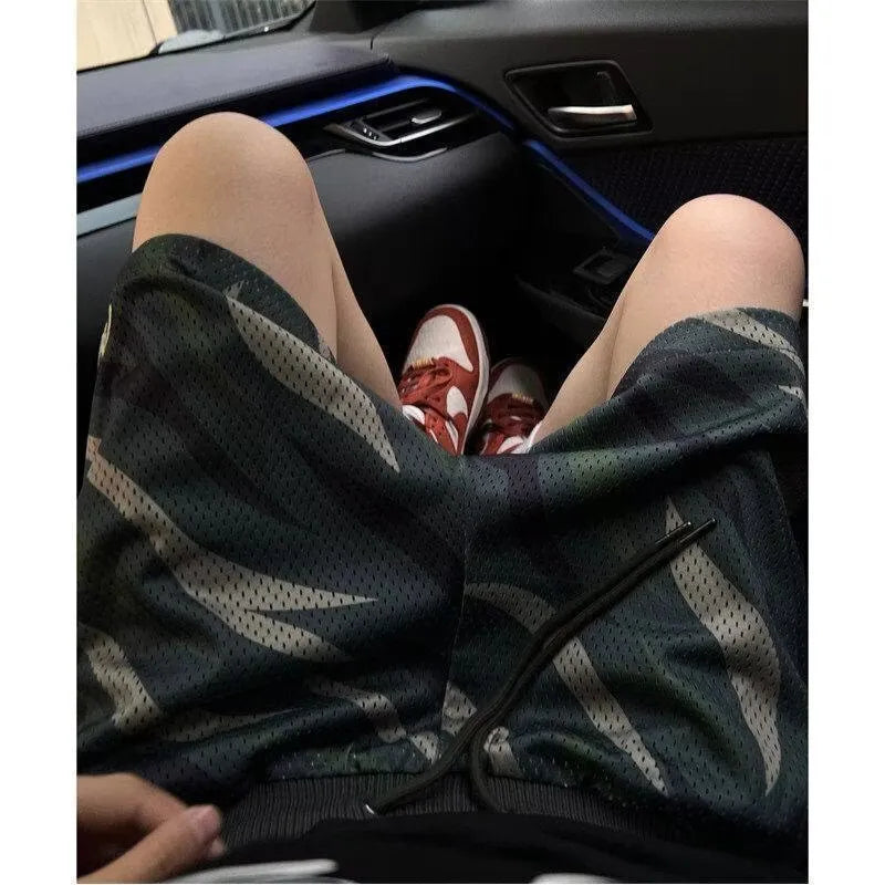 Men's camouflage pattern mesh shorts in straight-leg cut showing cotton-blend fabric texture