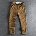Men's khaki work trousers with a buckle belt and three-dimensional cutting on a hanger.