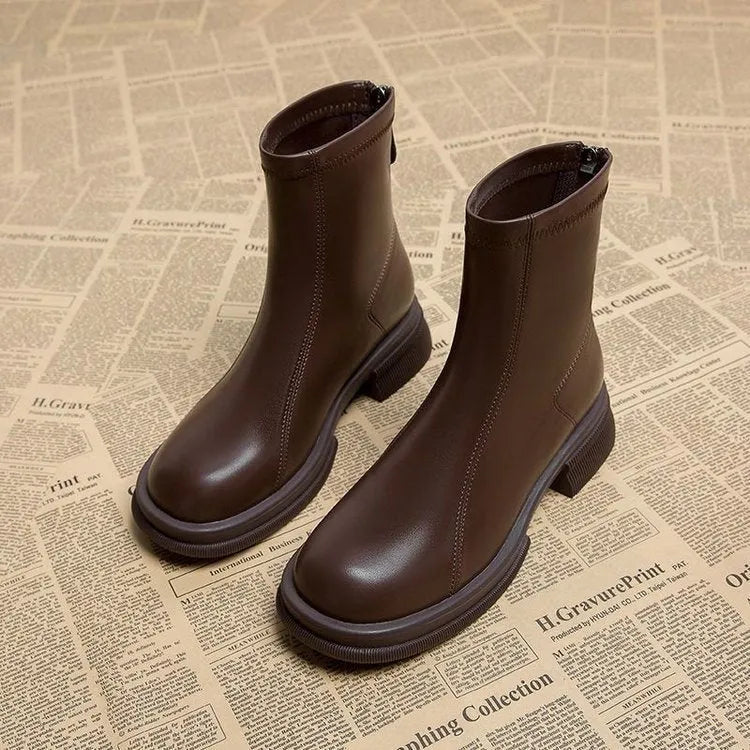 Women's black ankle boot with flat heel, round toe, and back zipper on a white background