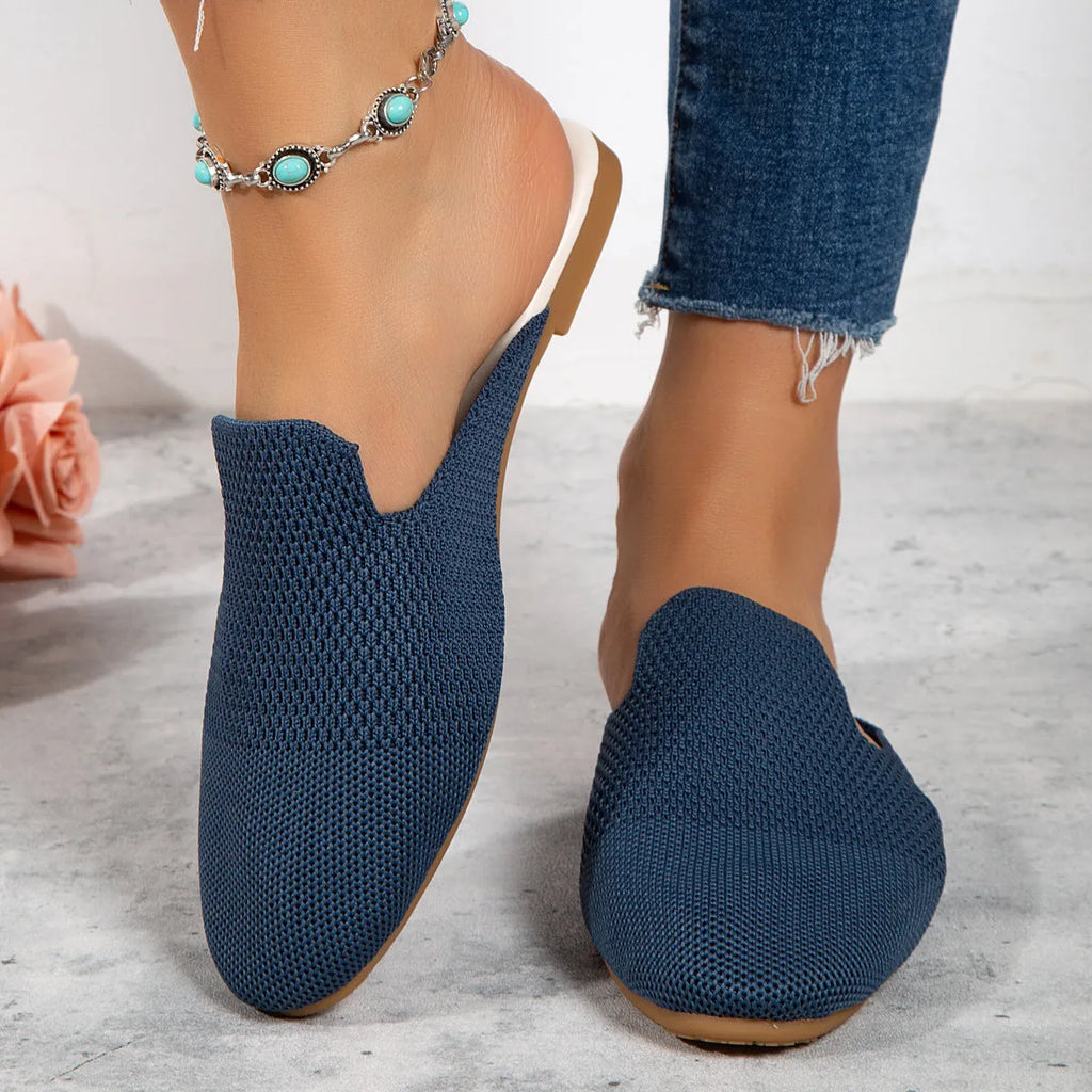 Apricot coloured mesh slip-on sandals with a round toe and flat rubber sole on a wooden floor.