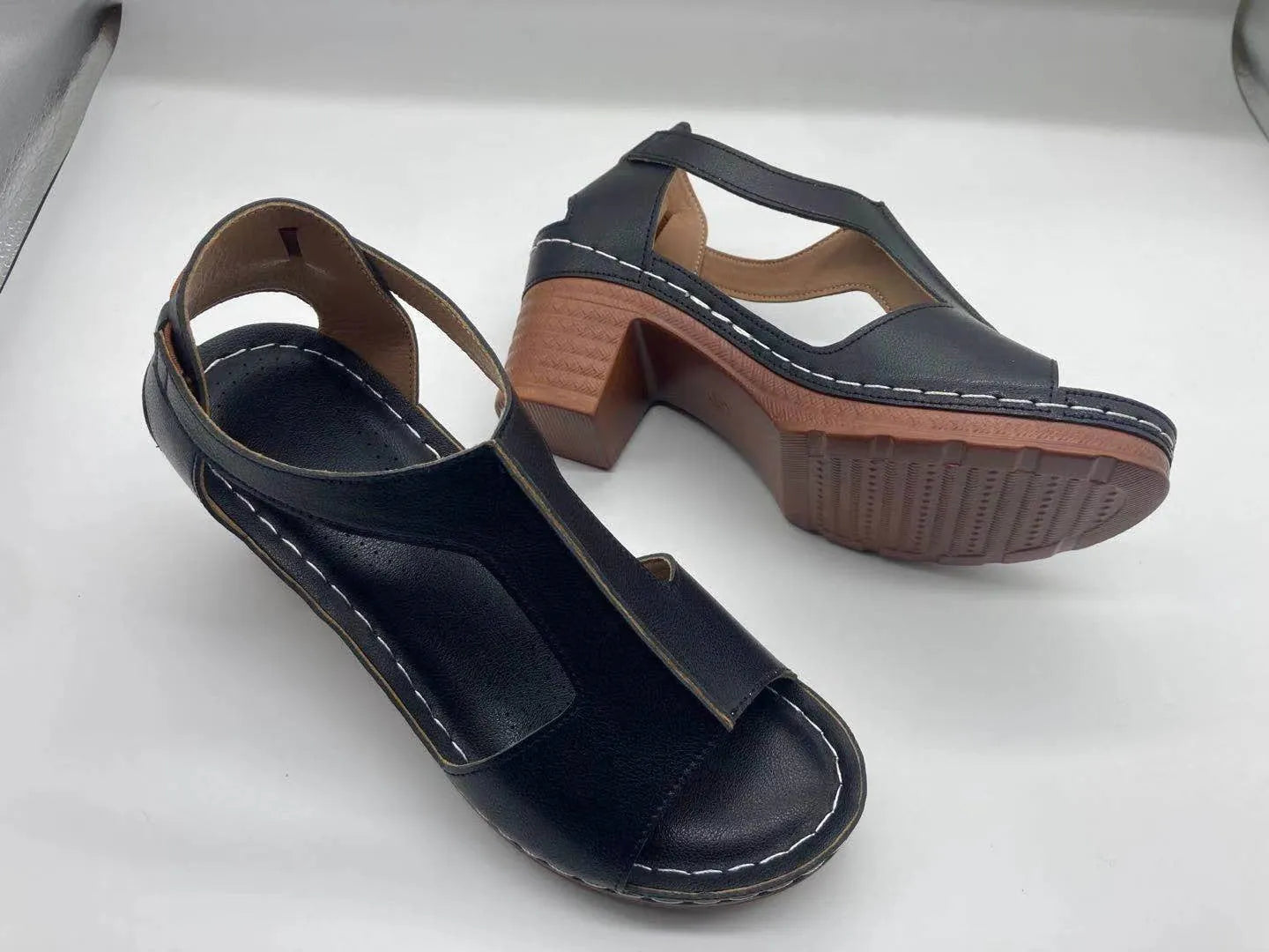 Plus size women's beige open toe wedge sandals with a buckle strap and low heel on a white background.