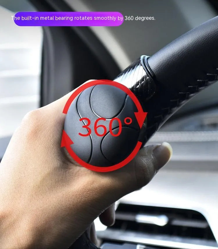 Black silicone steering wheel assist ball with metal bearing booster on a car steering wheel.
