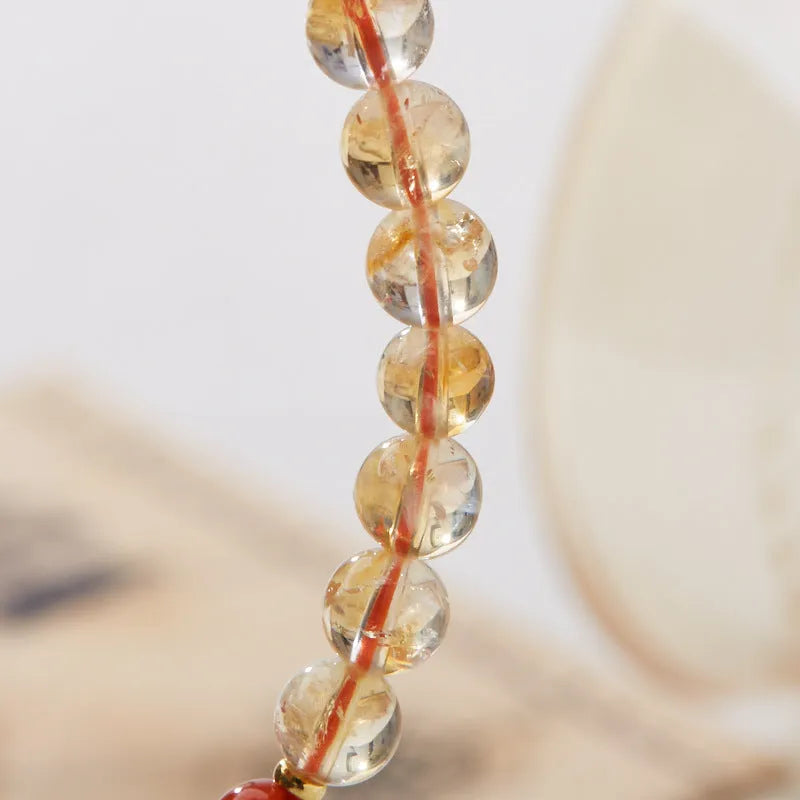Hand-woven citrine five sutra bracelet with 6mm geometric beads on a wrist.