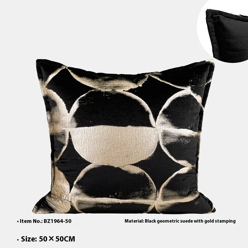 Black and gold abstract patterned flannel sofa cushion with removable cover on a grey sofa.