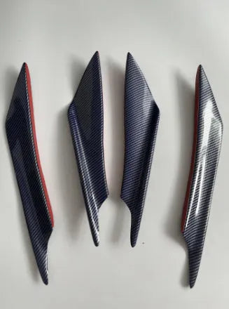 Set of four black ABS plastic bumper blade spoilers for car modification on a white background.