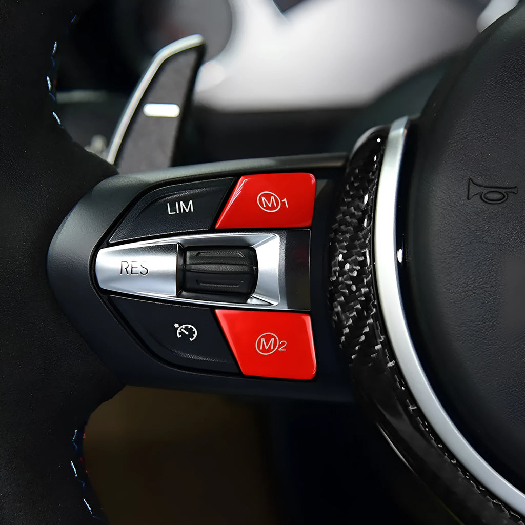 Pair of red and blue BMW steering wheel M1 and M2 mode replacement buttons on a white background.