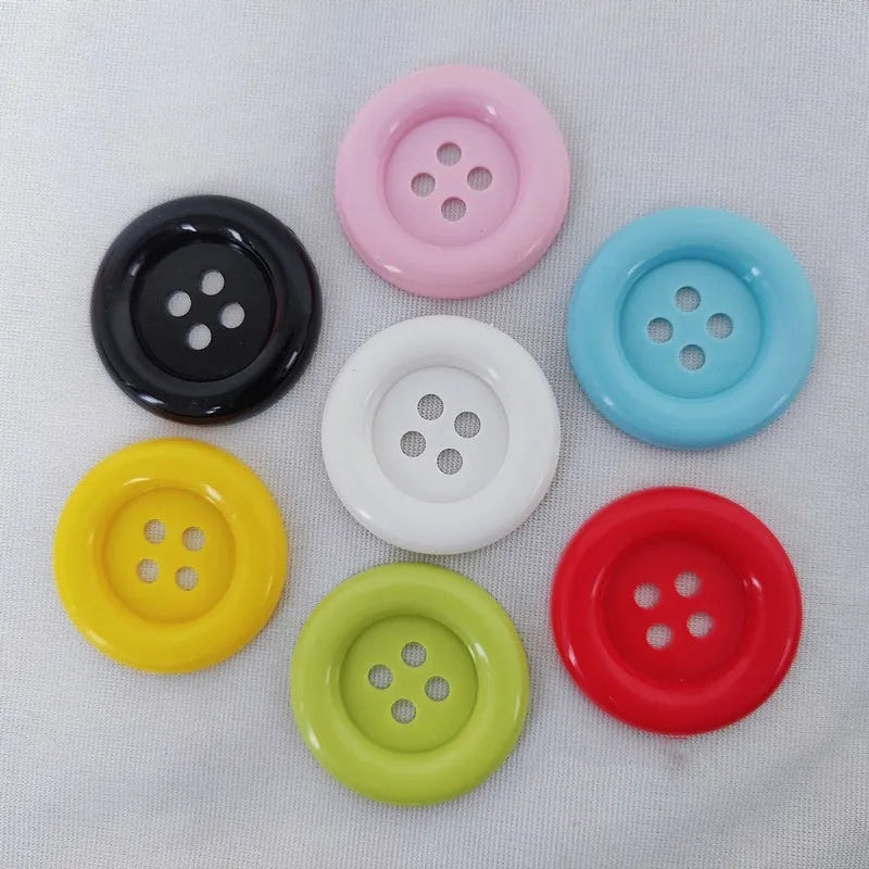 Oversized round plastic button with four holes in various colours and sizes from 38mm to 70mm.