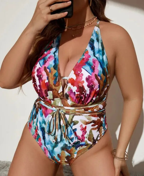 A purple women's one-piece halter swimsuit with a brief style, laid flat.