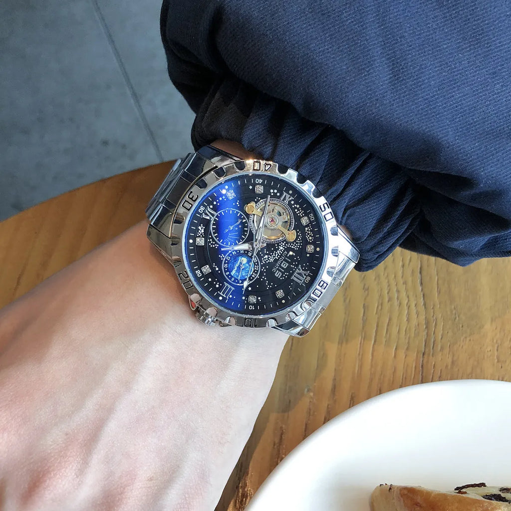 Men's silver automatic mechanical watch with black starry dial, luminous hands, and a leather strap.