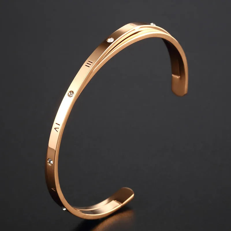 Open-ended stainless steel bracelet with inlaid zircon stones available in rose gold, steel, and gold electroplated finishes