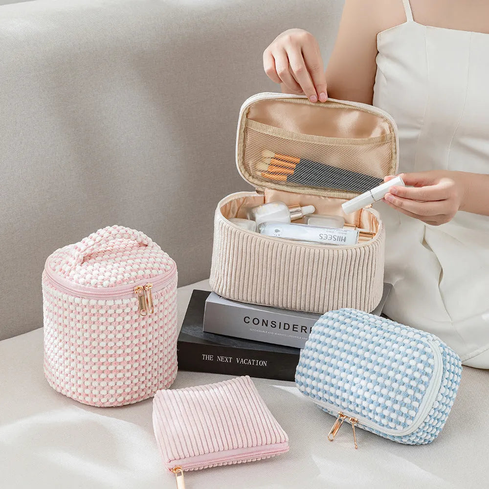 Four cube-shaped polyester makeup bags in coordinated set for cosmetics organisation
