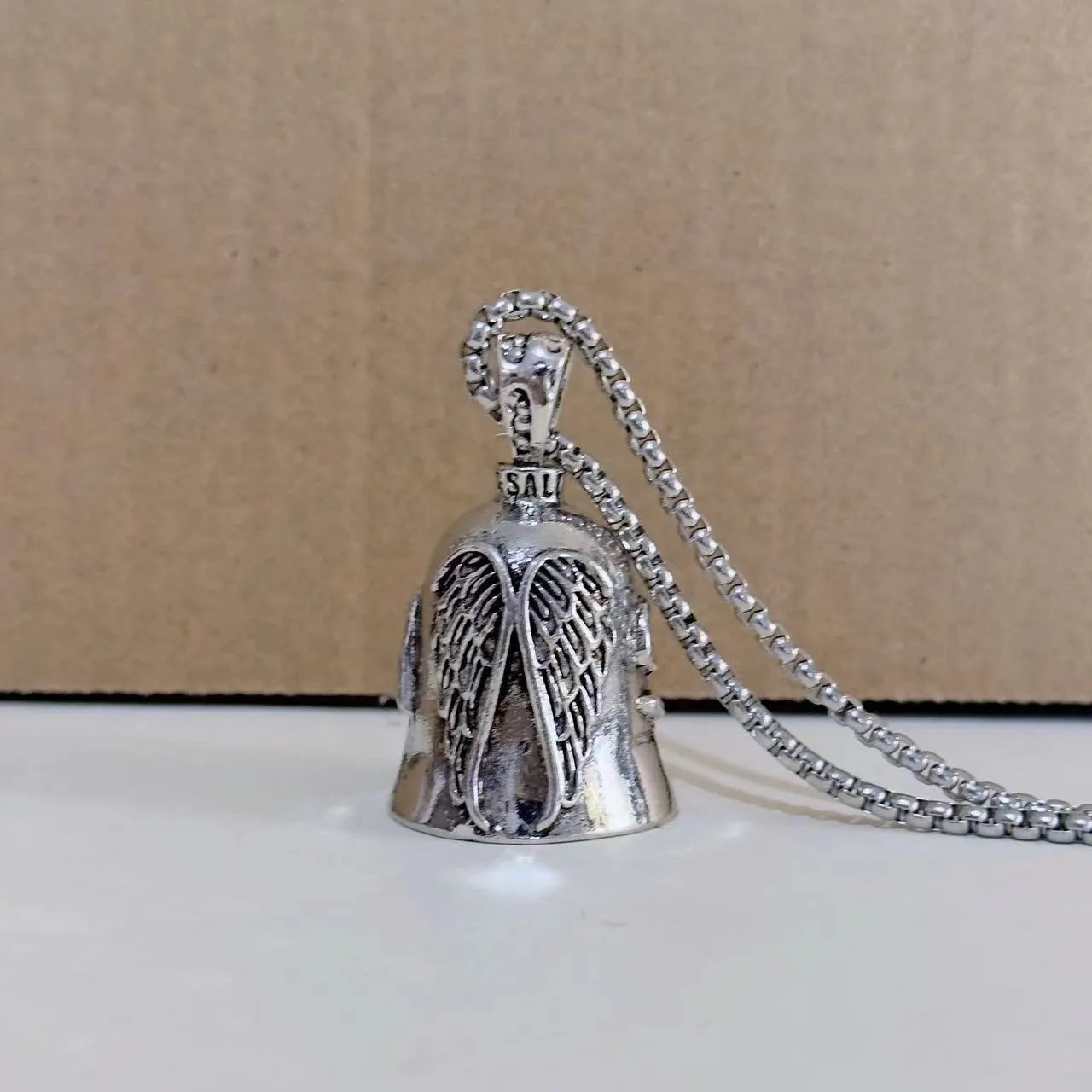 Vintage white electroplated alloy angel feather pendant on a keychain and a necklace chain.