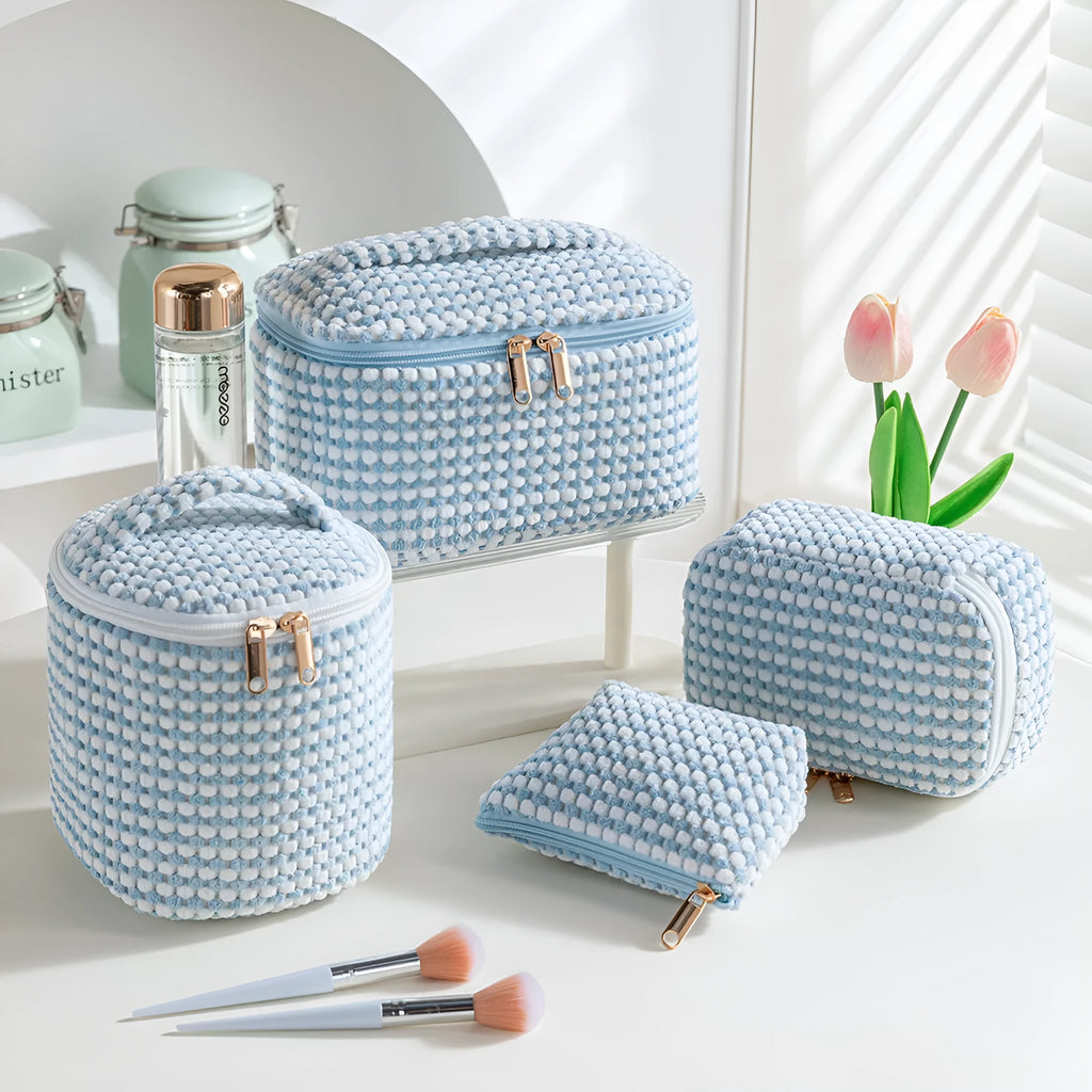 Four cube-shaped polyester makeup bags in coordinated set for cosmetics organisation