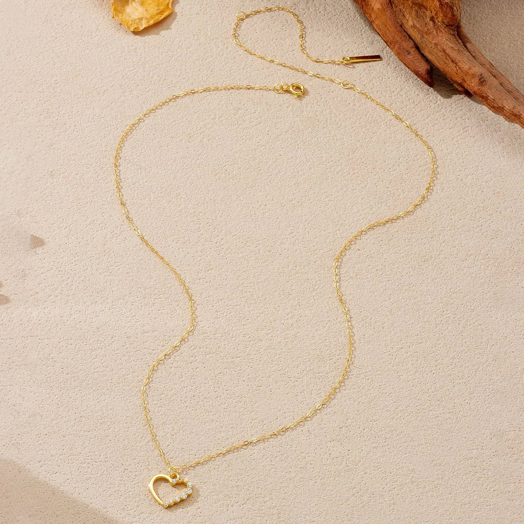 Close-up of a women's sterling silver hollow heart necklace with a circle detail, showing the white gold finish option.