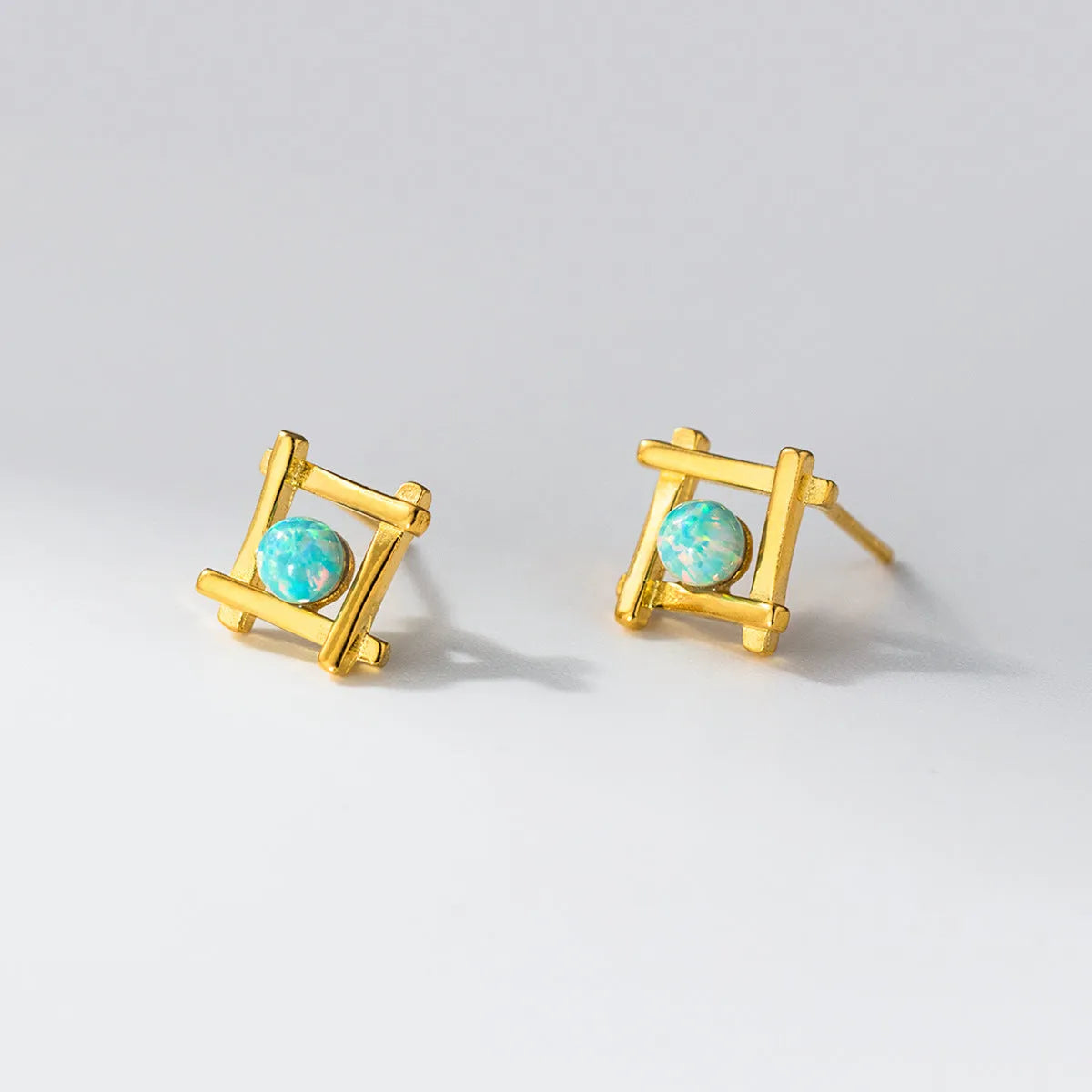 Geometric cross shaped stud earrings in sterling silver with angular design and gold or silver finish
