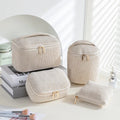 Four cube-shaped polyester makeup bags in coordinated set for cosmetics organisation