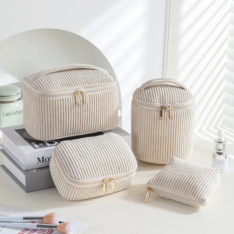 Four cube-shaped polyester makeup bags in coordinated set for cosmetics organisation