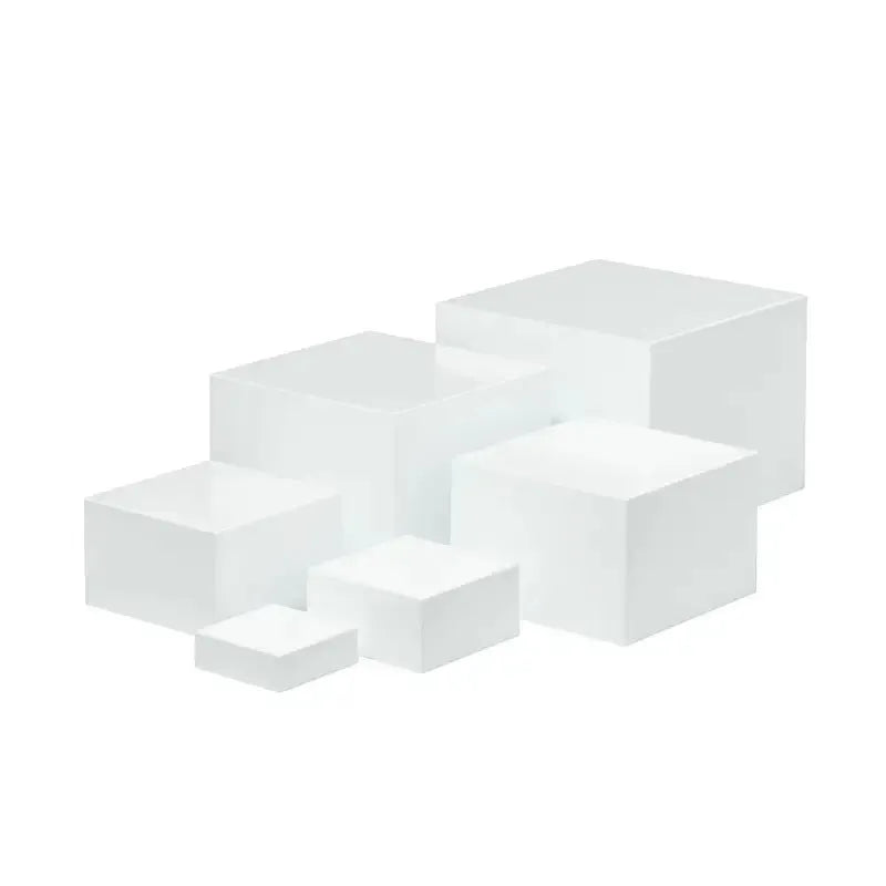 Six white plastic cube dessert display stands in graduated sizes from 3 to 8 centimetres.