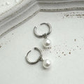 Geometric women's pearl earrings with titanium steel posts on a white background.