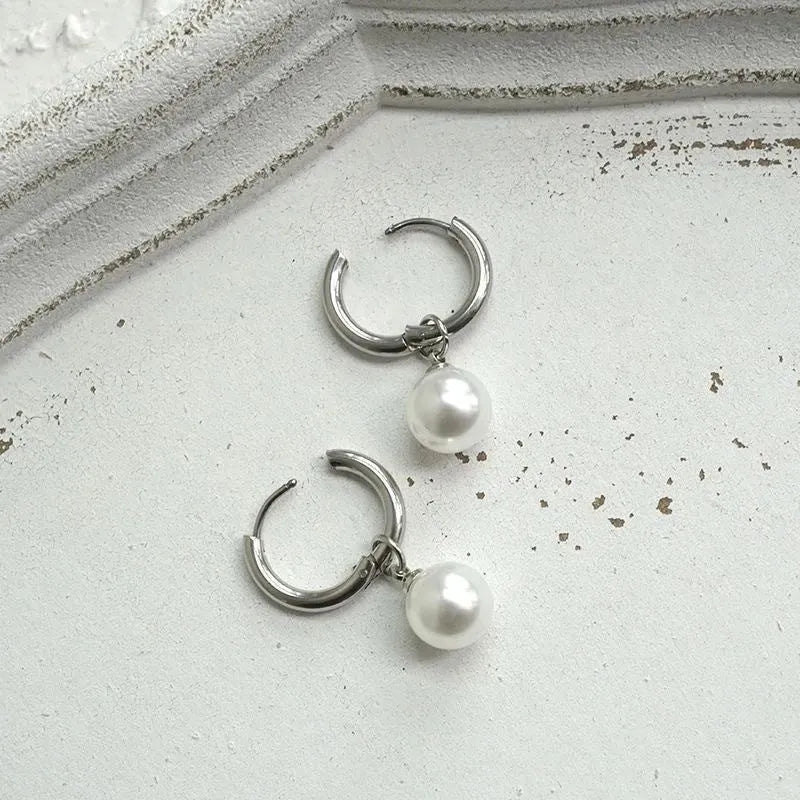 Geometric women's pearl earrings with titanium steel posts on a white background.