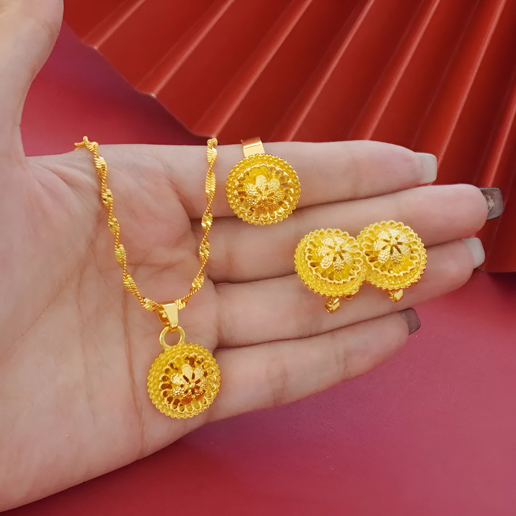 Three-piece gold electroplated jewellery set showing necklace with pendant, earrings, and matching ring
