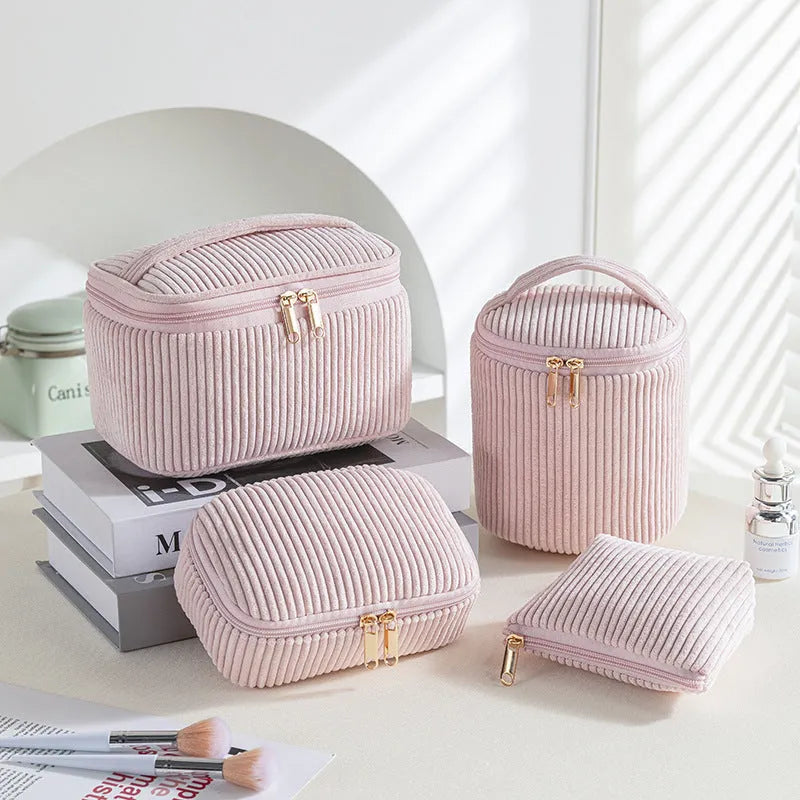 Four cube-shaped polyester makeup bags in coordinated set for cosmetics organisation
