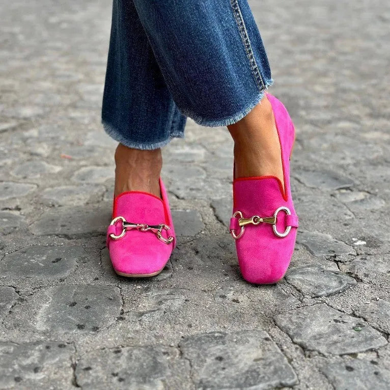 Green suede loafers with metal fastener detail showing flat rubber sole and round toe design