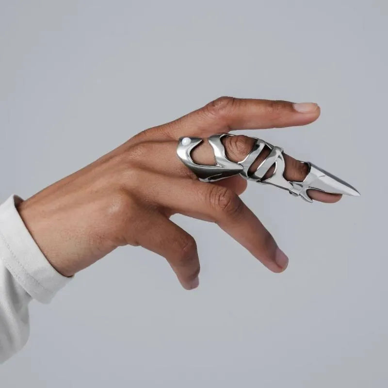 Silver colour alloy metal punk armour finger stall ring on a finger.