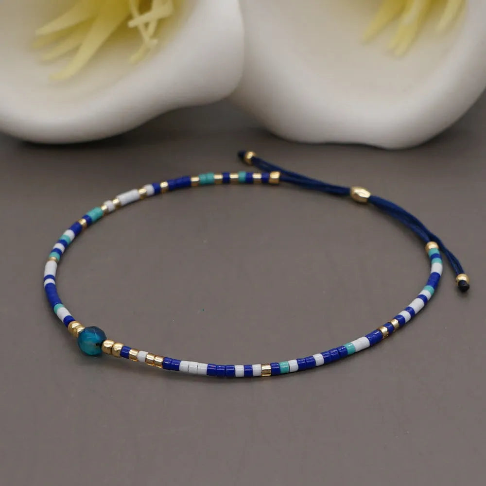 Women's handmade bohemian bracelet with colourful geometric glass and glaze beads on a wrist.