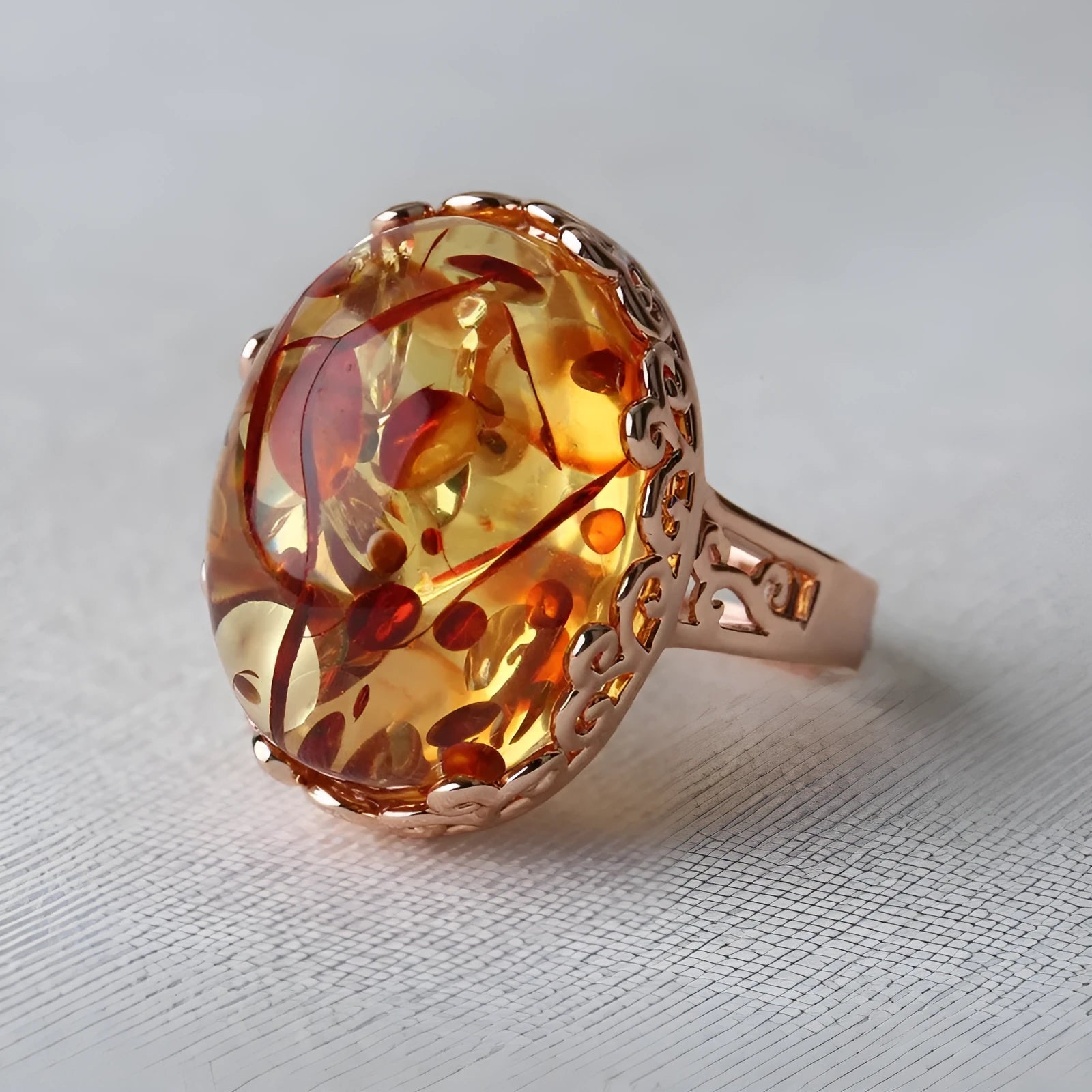 Close-up of a beeswax amber ring with a genuine amber stone on an alloy band, showing retro ethnic style.