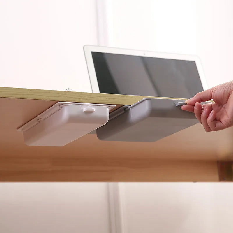 White plastic adhesive storage drawer with a covered grid design, shown mounted under a wooden desk.
