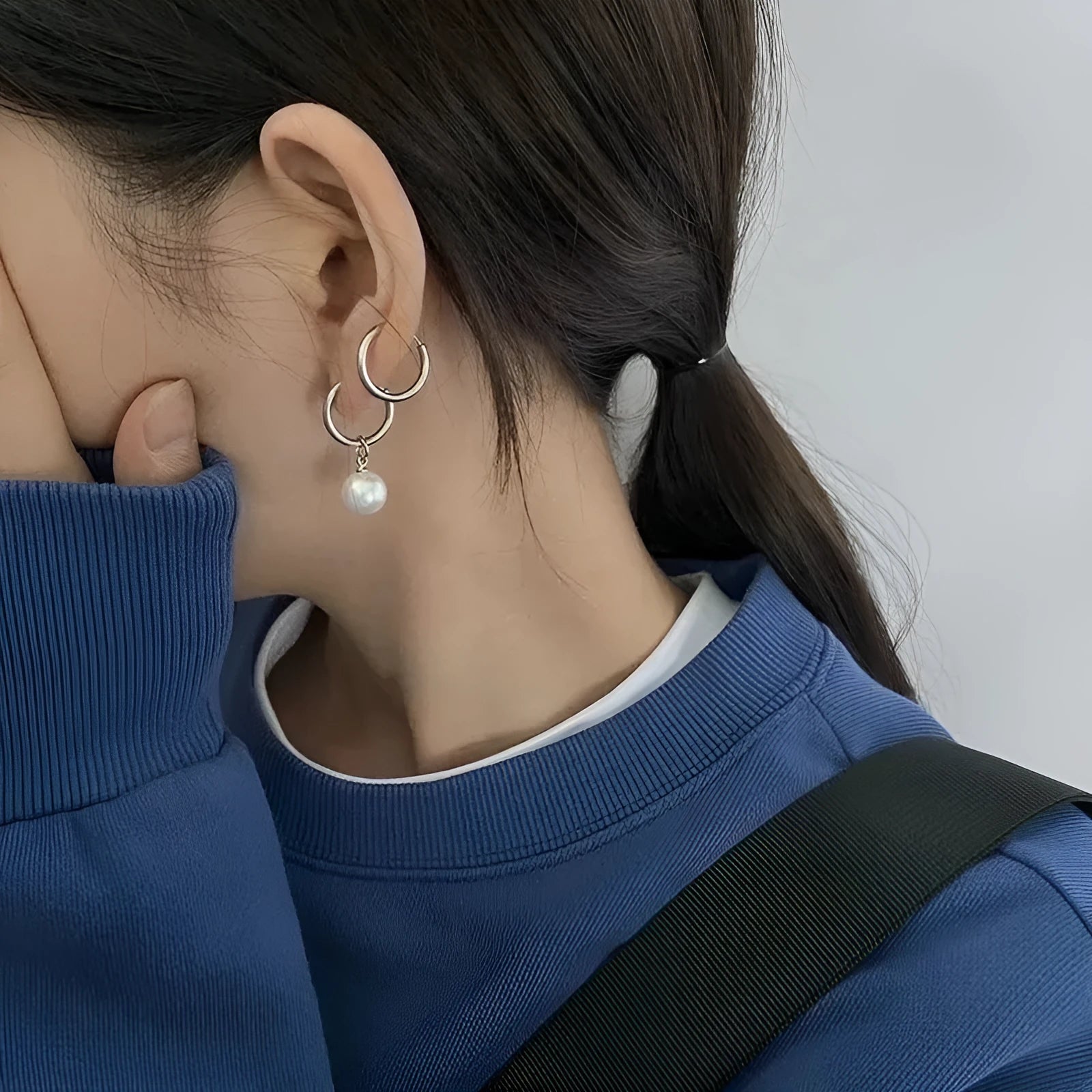 Geometric women's pearl earrings with titanium steel posts on a white background.