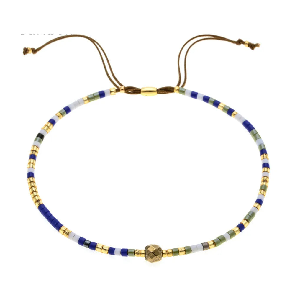 Women's handmade bohemian bracelet with colourful geometric glass and glaze beads on a wrist.