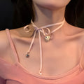 Close-up of a women's alloy necklace with a ribbed heart pendant on a clavicle-length chain.