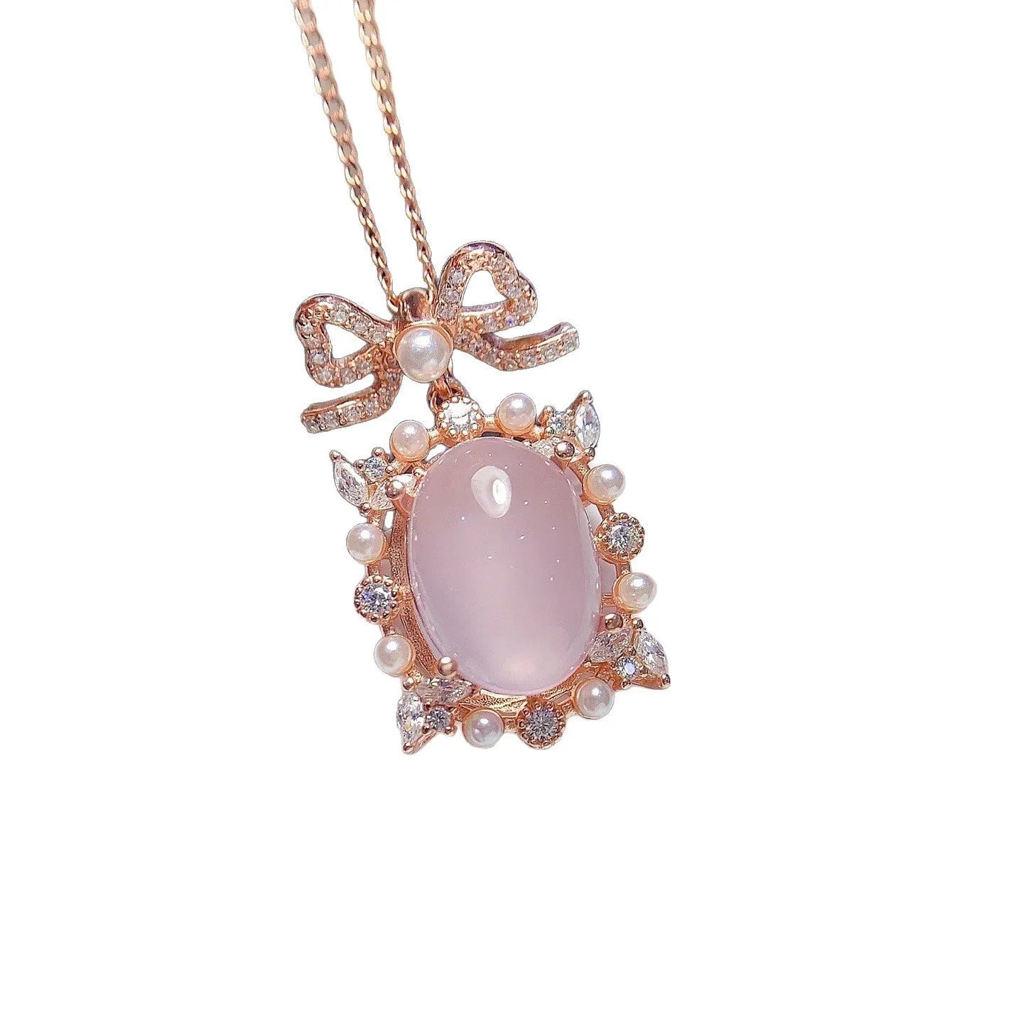Close-up of a geometric silver pendant with a pink rose quartz stone and rose gold plating on a chain.