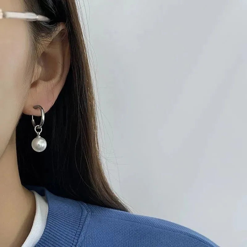 Geometric women's pearl earrings with titanium steel posts on a white background.