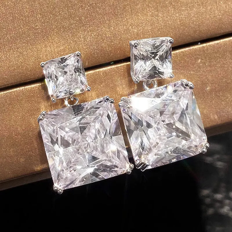 A pair of geometric square copper earrings for women, shown in white gold and gold colour finishes.