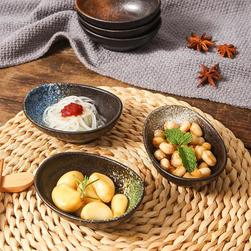 Japanese ceramic oval sauce dipping bowl with traditional underglaze pattern on white background