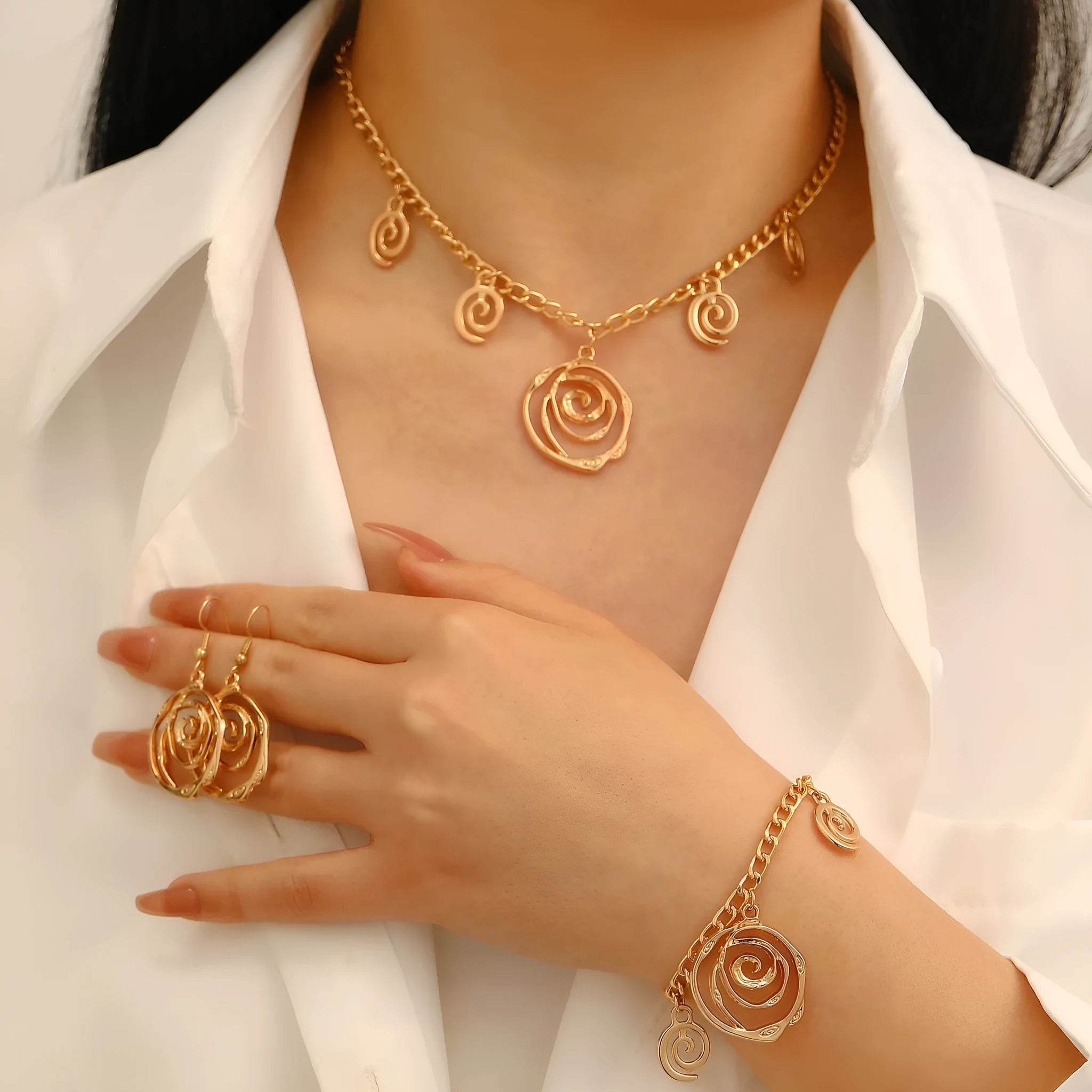 Women's spiral donut jewellery set showing bracelet, earrings, and adjustable necklace in gold tone