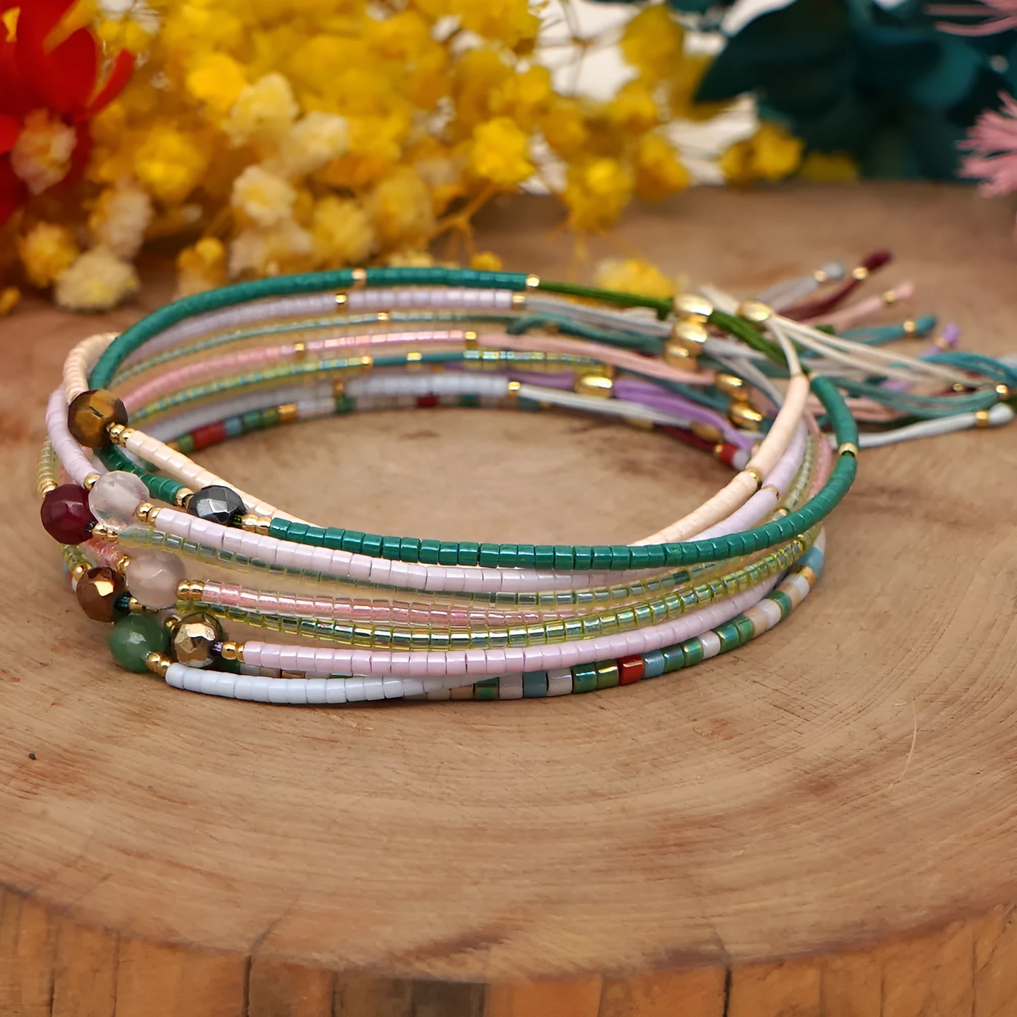Women's handmade bohemian bracelet with colourful geometric glass and glaze beads on a wrist.