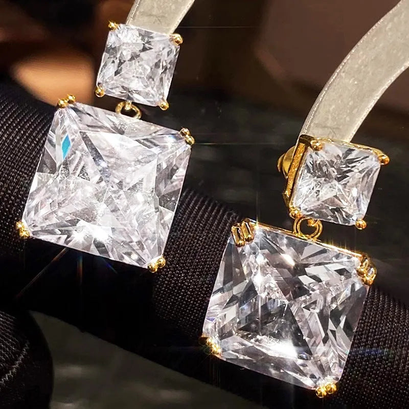 A pair of geometric square copper earrings for women, shown in white gold and gold colour finishes.