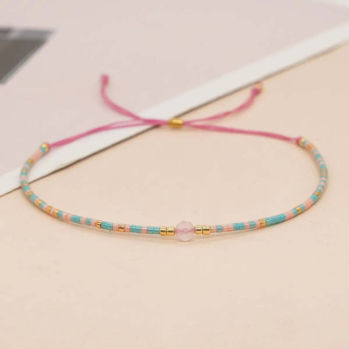 Women's handmade bohemian bracelet with colourful geometric glass and glaze beads on a wrist.