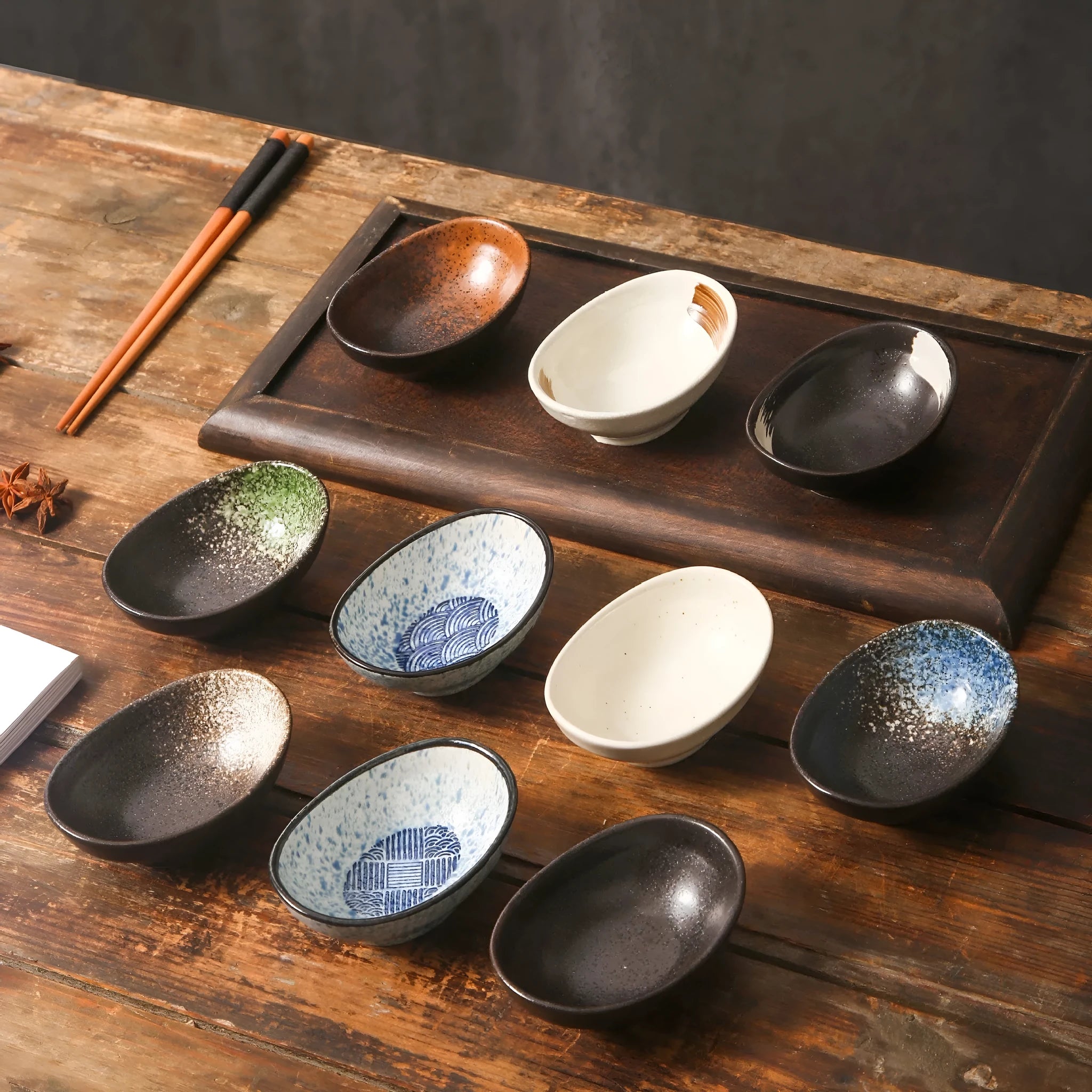 Japanese ceramic oval sauce dipping bowl with traditional underglaze pattern on white background