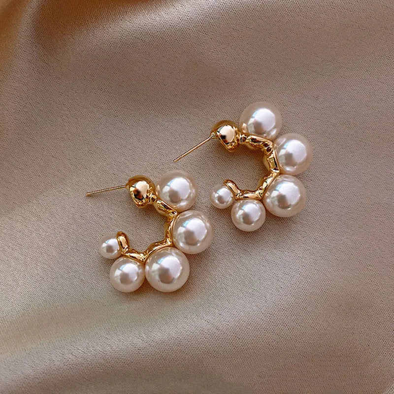 A pair of red alloy drop earrings featuring a small bell charm on a stud fitting.