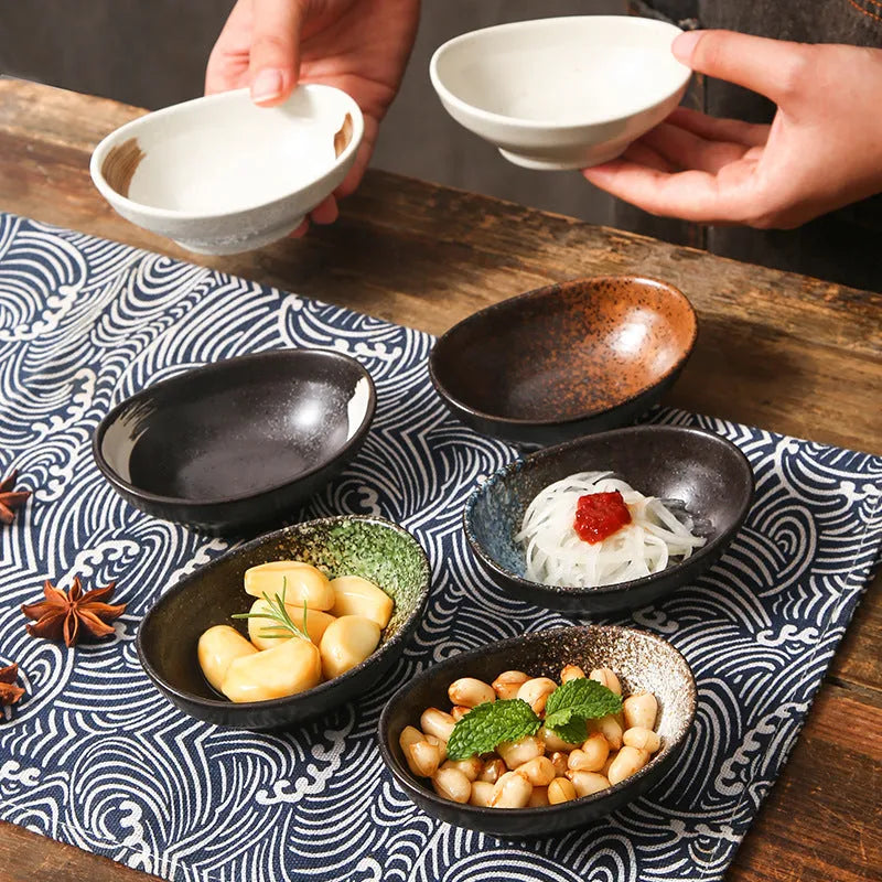 Japanese ceramic oval sauce dipping bowl with traditional underglaze pattern on white background