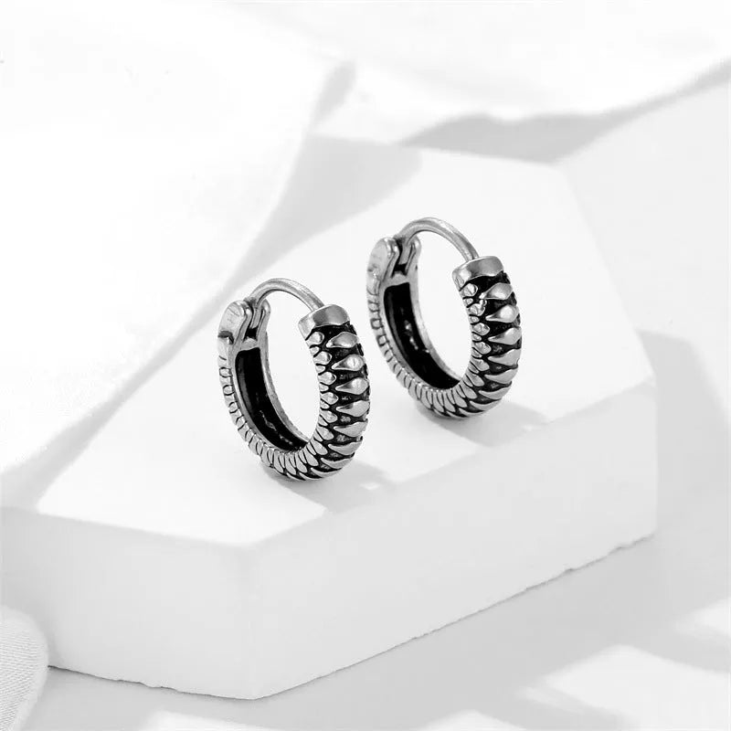 Silver geometric earrings with retro twist design and striped detailing on circular stainless steel form