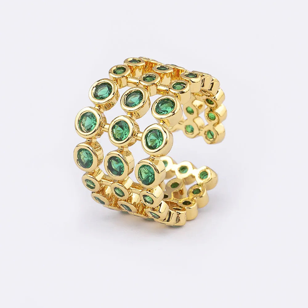 Gold-coloured wide band copper ring with large green zircon stones in a three-layer setting.